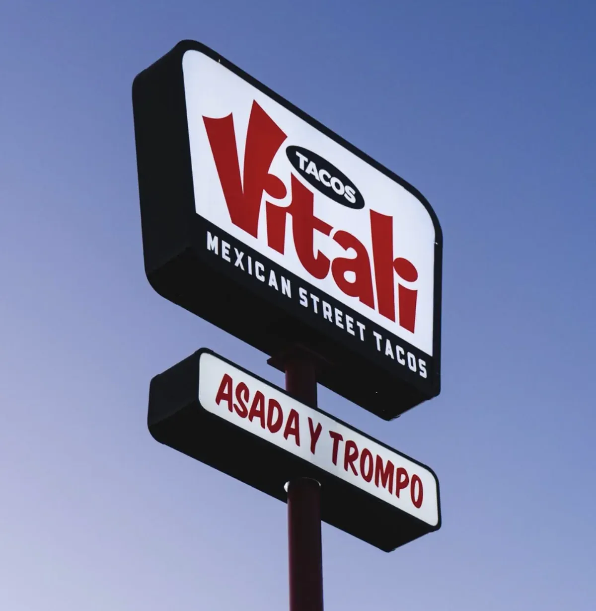 The red Tacos Vitali sign outside a taquería